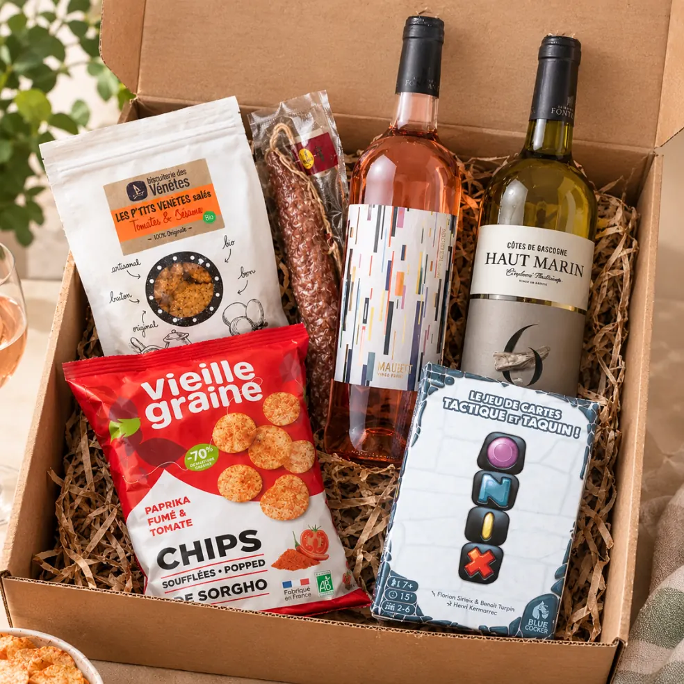 La box Maxi Plaisir ouverte : le jeu ONIX, des chips de sorgho, des biscuits apéritifs, un saucisson et le vin au choix